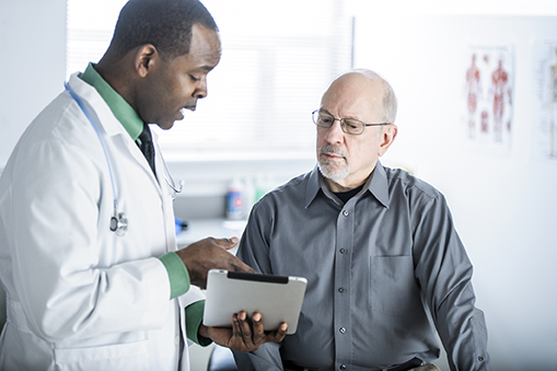 African American Doctor Talking To Patient In Office